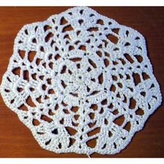 a crocheted doily on a wooden table