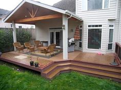 a covered patio with chairs and an umbrella