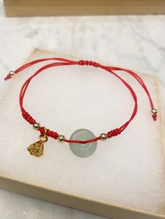 "Red string Jade Bracelet. Natural Jade donut and 18k gold-plated beads and lotus seed Charm. Adjustable size. *  This bracelet is made of high-quality nylon cord with a natural jade donut (Burmese jade) and 18k gold-plated beads and lotus seeds charm. *  The jade charm is about 10mm, the beads are 4mm. *  Your bracelet will arrive in a gift box ❖ The gemstones are natural, each stone is unique and beautiful so please expect slight variations in color, texture, and size. ❖ The bracelet is made t Adjustable Gemstone Beads Bracelets For Good Luck, Spiritual Red Jade Jewelry, Spiritual Yellow Gold Beaded Bracelets As Gift, Gemstone Beaded Bracelets For Festivals And Gifts, 108 Beads Bracelet Jewelry Gift, Handmade Red Jade Bracelets, Adjustable Red Jade Bracelet, Red Jade Bracelet As Gift, Red Jade Bracelet Gift