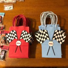 two paper bags sitting on top of a wooden table next to candy and candies