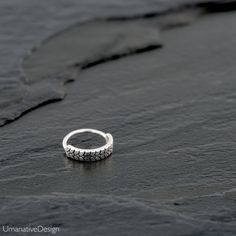 a silver ring sitting on top of a black rock