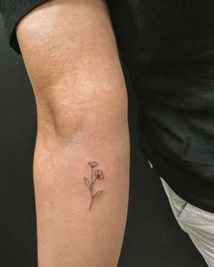 a person with a small flower tattoo on their arm