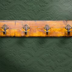 an old yellow and black metal handle on a green wall