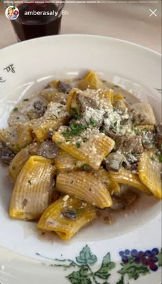 pasta with mushrooms and parmesan cheese in a white bowl