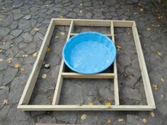 a blue bowl sitting on top of a wooden frame