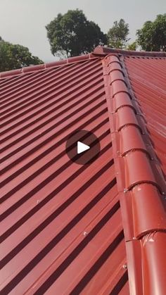 a red metal roof with trees in the background