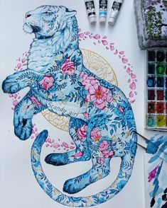 an image of a tiger with flowers on it's body and some paintbrushes