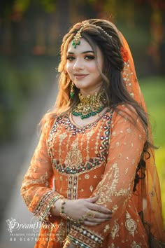 a woman wearing an orange outfit and jewelry