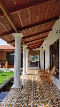 an outdoor covered porch with chairs and water feature