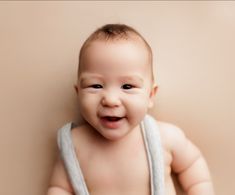 a baby is smiling while wrapped in a towel