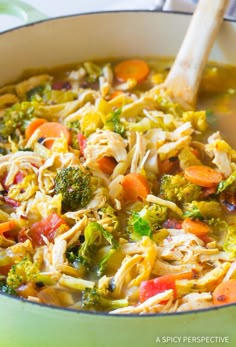 a pot filled with broccoli, carrots and noodles