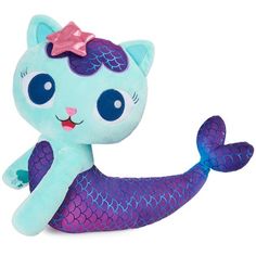 a stuffed animal with a pink bow on it's head sitting next to a mermaid tail