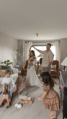 a man and two children playing in a living room