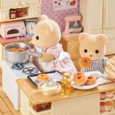 two teddy bears are making donuts in a dollhouse kitchen with food on the counter