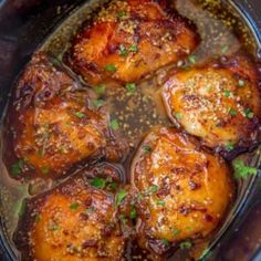 chicken thighs in a slow cooker with herbs and seasoning on the side, ready to be cooked