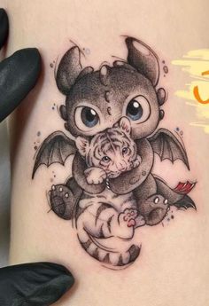 a small tattoo on the side of a woman's thigh with a dragon and tiger hugging