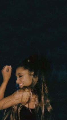 a woman with long hair standing in the dark