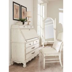 a white dresser and chair in a room