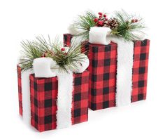 two red and black plaid christmas gift bags with pine cones on top, one wrapped in white flannel