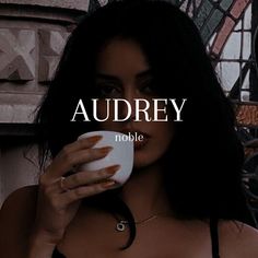 a woman holding a cup in front of her face with the words audrey noble on it