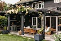 an outdoor dining area with wicker chairs and table surrounded by greenery on the patio