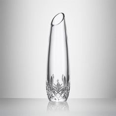 a clear glass vase sitting on top of a white countertop next to a wall