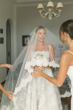 the bride is getting ready to walk down the aisle in her wedding dress and veil