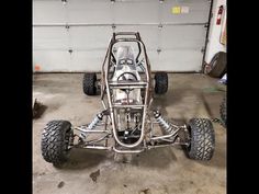 an off - road vehicle parked in a garage with four tires on the front and rear wheels