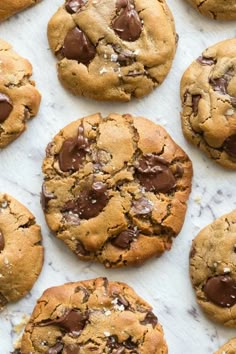 chocolate chip cookies are arranged on a white surface