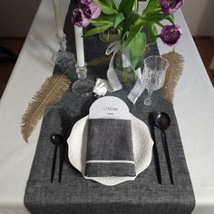 a place setting with flowers and candles on the table