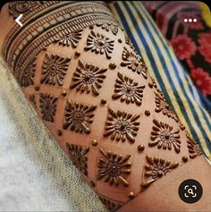 a woman's arm with henna tattoos on it