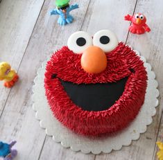 a red cake with sesame street characters on it