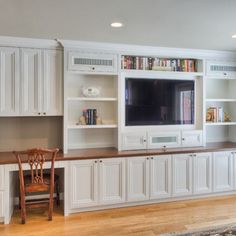 a large entertainment center with built in bookshelves, cabinets and a television mounted on the wall