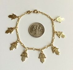 "18k gold filled 8 hamsa baby bracelet. for good luck and protection 5.5\" long. pulsera de mano en 18k gold filled para bebe. para buena suerte y proteccion 5.5\" largo" Gold Spiritual Charm Bracelet With Lobster Clasp, Spiritual Gold Charm Bracelet Hypoallergenic, Hypoallergenic Gold Spiritual Charm Bracelet, Nickel-free Gold Spiritual Charm Bracelet, Gold Nickel-free Spiritual Charm Bracelet, Personalized Gold Spiritual Charm Bracelet, Personalized Spiritual Gold Charm Bracelet, Adjustable Spiritual Yellow Gold Charm Bracelet, Handmade Symbolic Gold Charm Bracelet