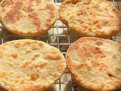 four cheese pizzas cooling on a wire rack