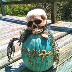 a skull sitting on top of a blue pumpkin