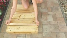 a woman bending over on a wooden bench