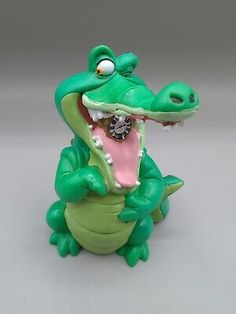 a toy alligator with its mouth open and it's teeth wide open, sitting on a