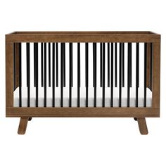 a wooden crib with white sheets on the bottom and black trim around the sides