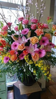 a vase filled with lots of different colored flowers