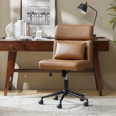 a brown leather office chair sitting in front of a desk with a lamp on it