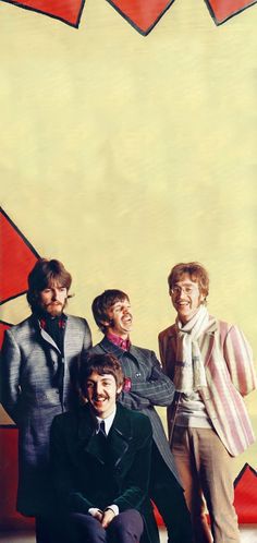 the beatles are posing for a photo in front of a red and yellow star shaped background