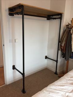 an iron pipe and wood shelf in a bedroom