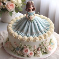 there is a cake that looks like a woman in a blue dress on the table