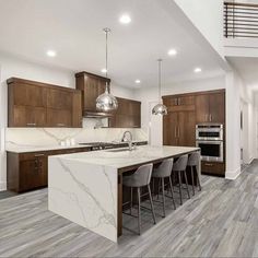 a large kitchen with an island and marble counter tops in the middle of the room