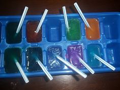 the tray is filled with different colored liquids and toothpicks on sticks in it