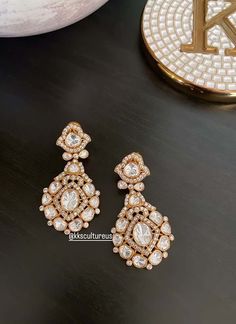 "A jewel in itself, statement gold plated gold finish stud earrings studded with Moissanite Polki in bezel. Light in weight.. Perfect party wear on any Indian / Indo Western Attire. Premium Quality as always.  👉🏻Size: 2\" length 👉🏻Gold plated on Brass as base metal. 👉🏻Earrings Closure - Push Back & clip back. We want you to LOVE your new jewelry!  CARE TIP  1. Keep away from moisture and perfume 2. Store in cotton or zip lock bags or air tight boxes.  3. Spot cleaning only.  4. Jewelry is the last thing you should wear and the first thing you should remove.  Send us an email if you need help!  SHIPPING & TURNAROUND  We follow item dispatch in 1-2 business days for most of our shipments. All pre orders will take approximately 3 weeks. We offer Free domestic delivery across US. Most de Jeweled Drop Earrings For Gift, Gold Chandelier Earrings With 17 Diamonds, Dazzling Gold Diamond Chandelier Earrings, Gold Diamond Chandelier Earrings With Elegant Design, Party Hand Set Yellow Gold Earrings, Party Yellow Gold Hand Set Earrings, Elegant Gold Chandelier Earrings With Rose Cut Diamonds, Festive Gold-plated Earrings With 17 Jewels, Hand Set Gold Plated Earrings For Celebration