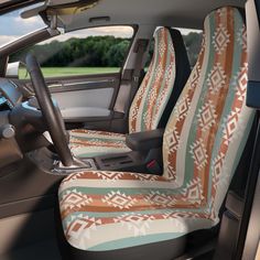 the interior of a car with two seats covered in native patterned blankets and steering wheel covers