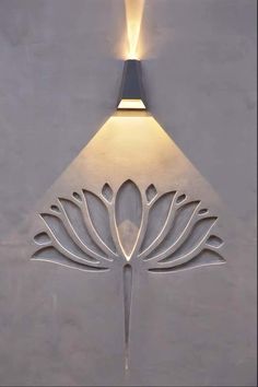 a light that is on the side of a building with a flower design on it