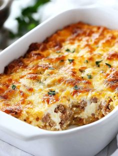 a casserole dish with meat and cheese in it on a white table cloth